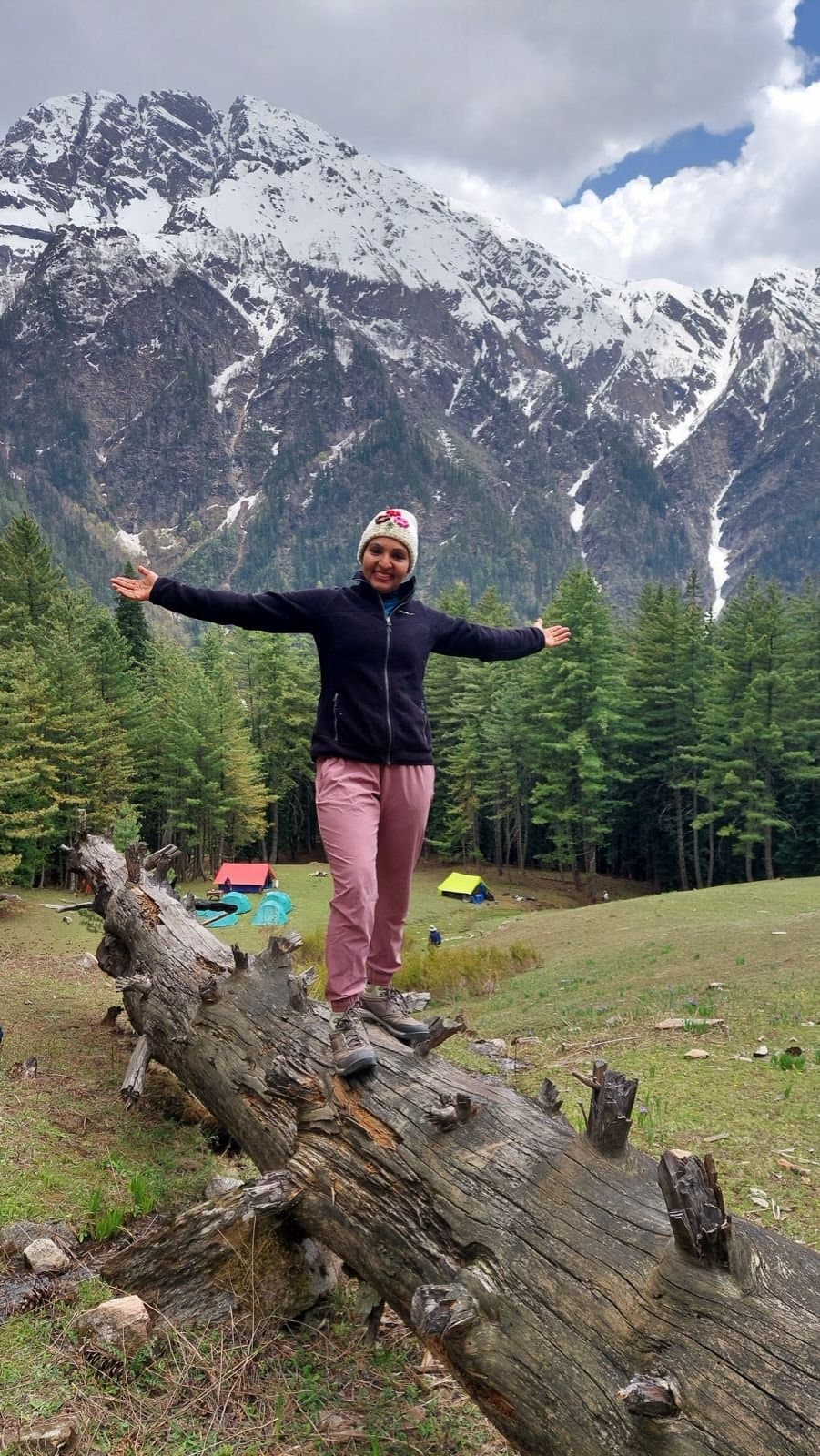 Srividya with arms open in front of snow-capped mountains