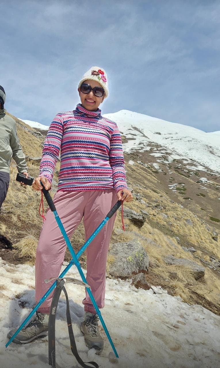 Srividya trekking through the snow with poles